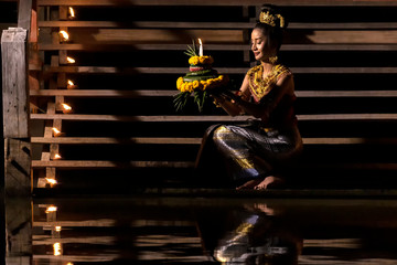 Loy krathong festival Thailand. Asian women are Loy krathong on a the river at night.