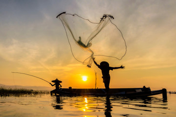 Fishermen Casting are going out to fish early in the morning with wooden boats, old lanterns and nets. Concept Fisherman's life style..