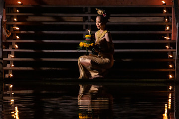 Loy krathong festival Thailand. Asian women are Loy krathong on a the river at night.
