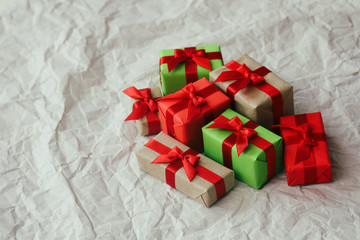 Set of gift boxes wrapped in craft paper and tie red satin ribbon. Christmas presents. Holiday mood. New year decor.