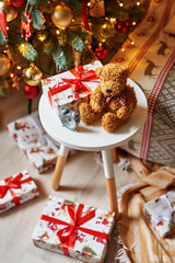 Christmas teddy bear soft toy on the background of the Christmas tree