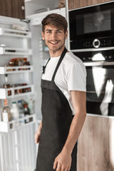 Fototapeta na wymiar young man standing in his cozy kitchen