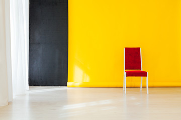 red chair in the interior of the room with a yellow background