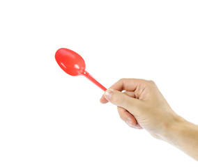 Hand holding plastic red disposable spoon. Close up. Isolated on white background