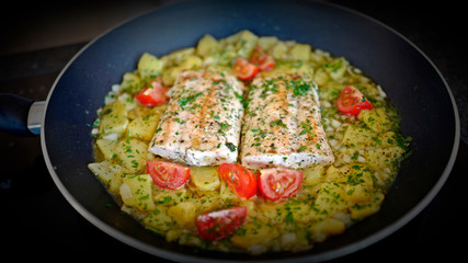 salmon fillet with potatoes and tomatoes in olive oil