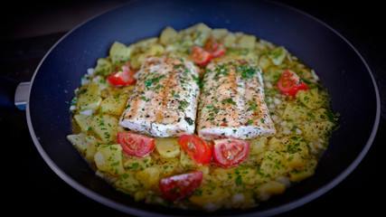 salmon fillet with potatoes and tomatoes in olive oil