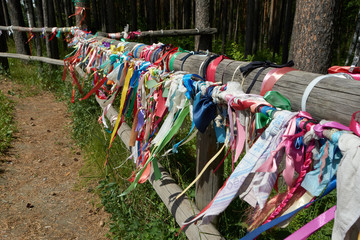 colorful ribbons tied to the fence of logs