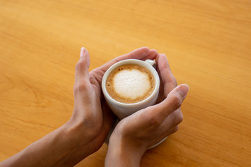 Mano sosteniendo un café en una mañana de otoño