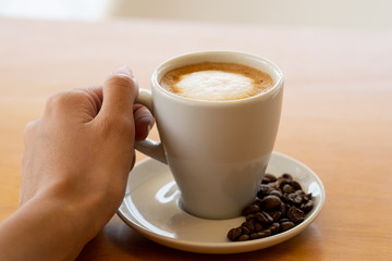 Mano sosteniendo un café en una mañana de otoño