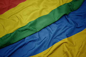 waving colorful flag of ukraine and national flag of bolivia.