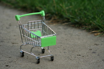 A mini shopping trolley on a table that shines on the sun symbolizing marketing and shopping as a concept of business.