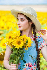 Portrait of a young beautiful girl in a field of sunflowers