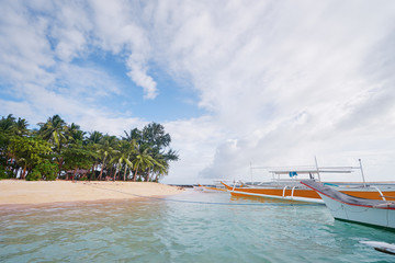 Beautiful landscape - tropical white sand beach with fishing boats. Siargao Island, Philippines.
