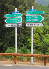 traffic sign with arrow and the text of city in Corsian language