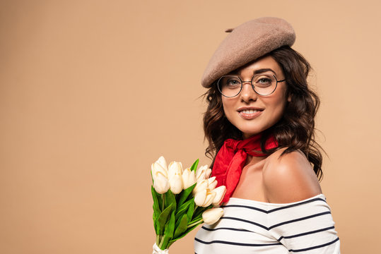french woman in beret holding bouquet on beige background