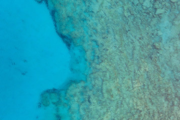 An aerial view of the beautiful Mediterranean sea, where you can se the rocky textured underwater corals and the clean turquoise water of blue lagoon Agia Napa