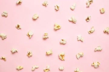 Top view of popcorn pattern on pink background. Unhealthy diet concept.