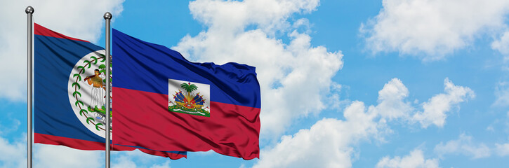 Belize and Haiti flag waving in the wind against white cloudy blue sky together. Diplomacy concept, international relations.