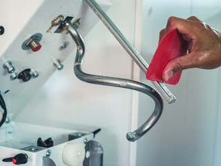 detail of baker's hand cleaning his kneader
