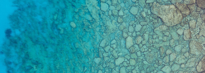 An aerial view of the beautiful Mediterranean sea, where you can se the rocky textured underwater corals and the clean turquoise water of blue lagoon Agia Napa