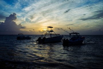 Botes en el amanecer en playa