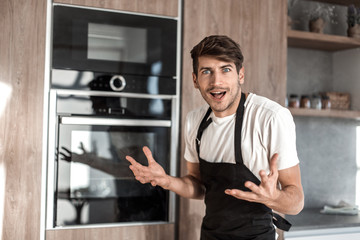Fototapeta na wymiar young man standing near broken oven on home kitchen