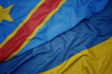 waving colorful flag of ukraine and national flag of democratic republic of the congo.