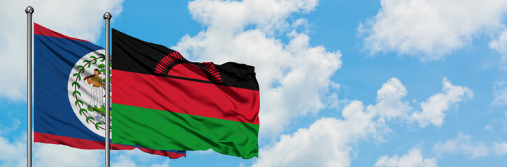 Naklejka premium Belize and Malawi flag waving in the wind against white cloudy blue sky together. Diplomacy concept, international relations.
