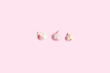 Flat lay composition with garlic on light pink background