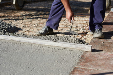  Construction workers working outdoors pouring concrete.