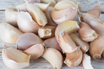 Slices of fresh garlic on a wooden table. Crop of garlic. Spicy seasoning for food.