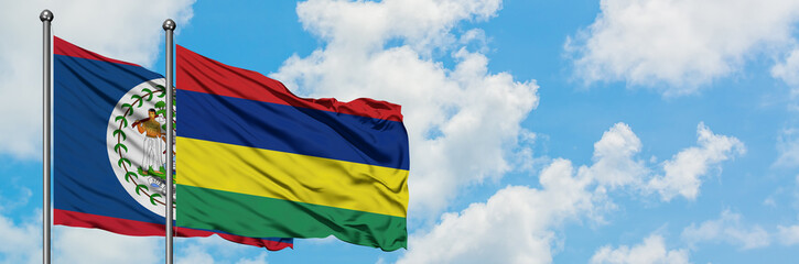 Fototapeta premium Belize and Mauritius flag waving in the wind against white cloudy blue sky together. Diplomacy concept, international relations.
