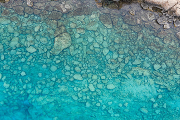 An aerial view of the beautiful Mediterranean sea, where you can se the rocky textured underwater corals and the clean turquoise water of blue lagoon Agia Napa