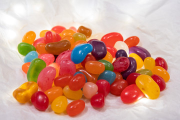 Close up of jelly beans on white paper. Halloween, sweet treat, candy concept. Trick or treat. Holiday, celebrations. Children’s sweets. Childhood dream. Colorful sweets.