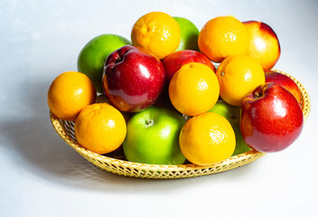 fresh fruit, in a straw basket, apples, tangerines, peaches.