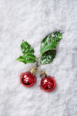 Christmas ornaments with holly berry covered in snow viewed from above. Top view