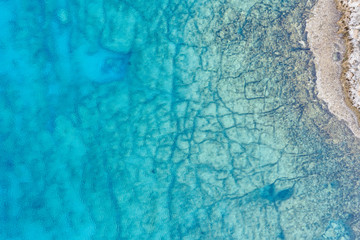 Fototapeta na wymiar An aerial view of the beautiful Mediterranean sea, where you can se the rocky textured underwater corals and the clean turquoise water of blue lagoon Agia Napa
