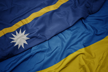 Fototapeta premium waving colorful flag of ukraine and national flag of Nauru .