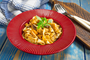 Tagliatelle pasta with chicken and boletus mushrooms.