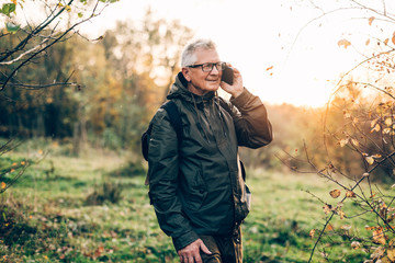 Senior man using smartphone in forest