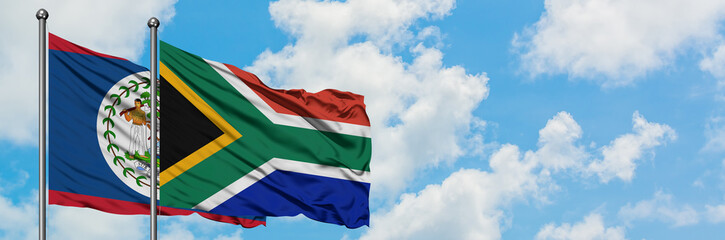Belize and South Africa flag waving in the wind against white cloudy blue sky together. Diplomacy concept, international relations.