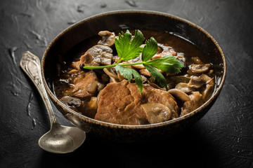 Stewed pork chop in a bright mushroom sauce.