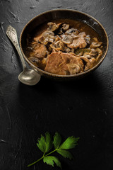 Stewed pork chop in a bright mushroom sauce.