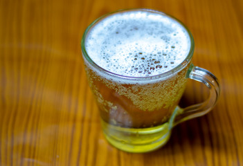 foam beer in a glass on the table