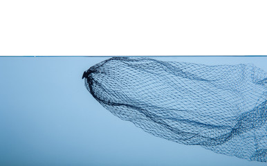 Black mesh or plastic trash floating in clear blue water on white background environmental problems concept
