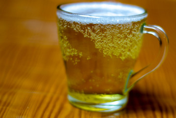 yellow juice in a glass, on a beige background