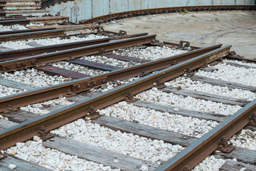 Naklejka premium Industrial background featuring detail of old railway station with rusty rails illustrating vintage industry or transport technology.