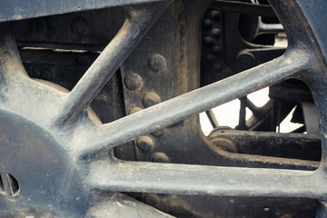 Industrial or transportation or steam punk vintage background with detail of old rusty steam locomotive featuring crank mechanism, frame and  wheels. 
