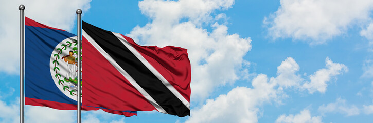 Belize and Trinidad And Tobago flag waving in the wind against white cloudy blue sky together. Diplomacy concept, international relations.