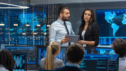 Head of the Department and Project Manager Discuss Work Process Using Data on Tablet Computer....